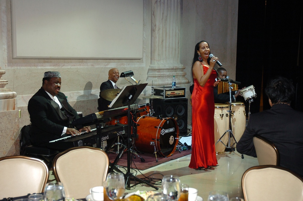 Angela Stribling sings in a red gown with a live jazz band at the Franklin Institute in Philadelphia.