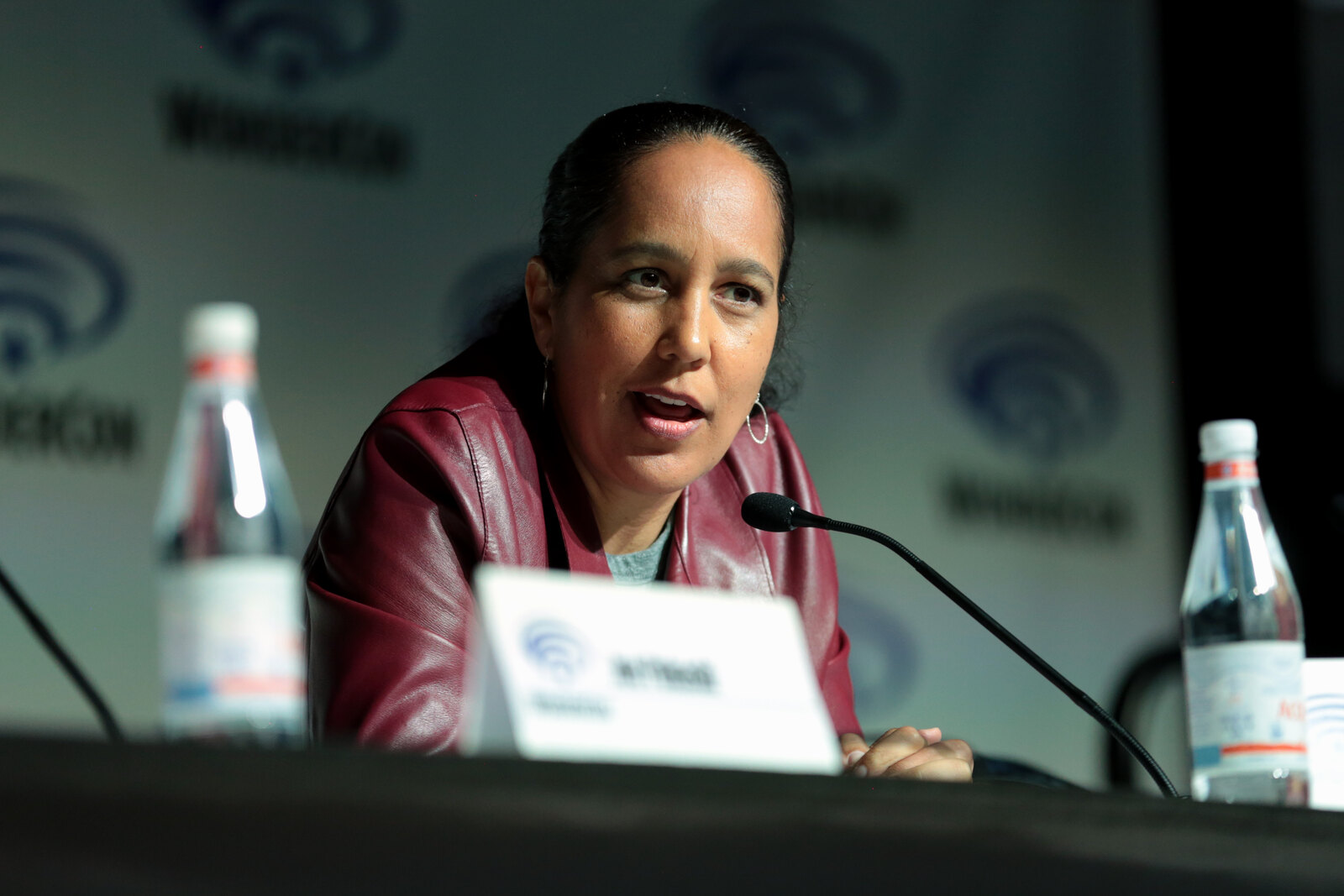 Gina Prince-Bythewood speaking into a microphone during a 2018 WonderCon panel