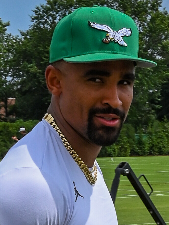 Philadelphia Eagles quarterback Jalen Hurts walking onto a training-camp field in July 2025