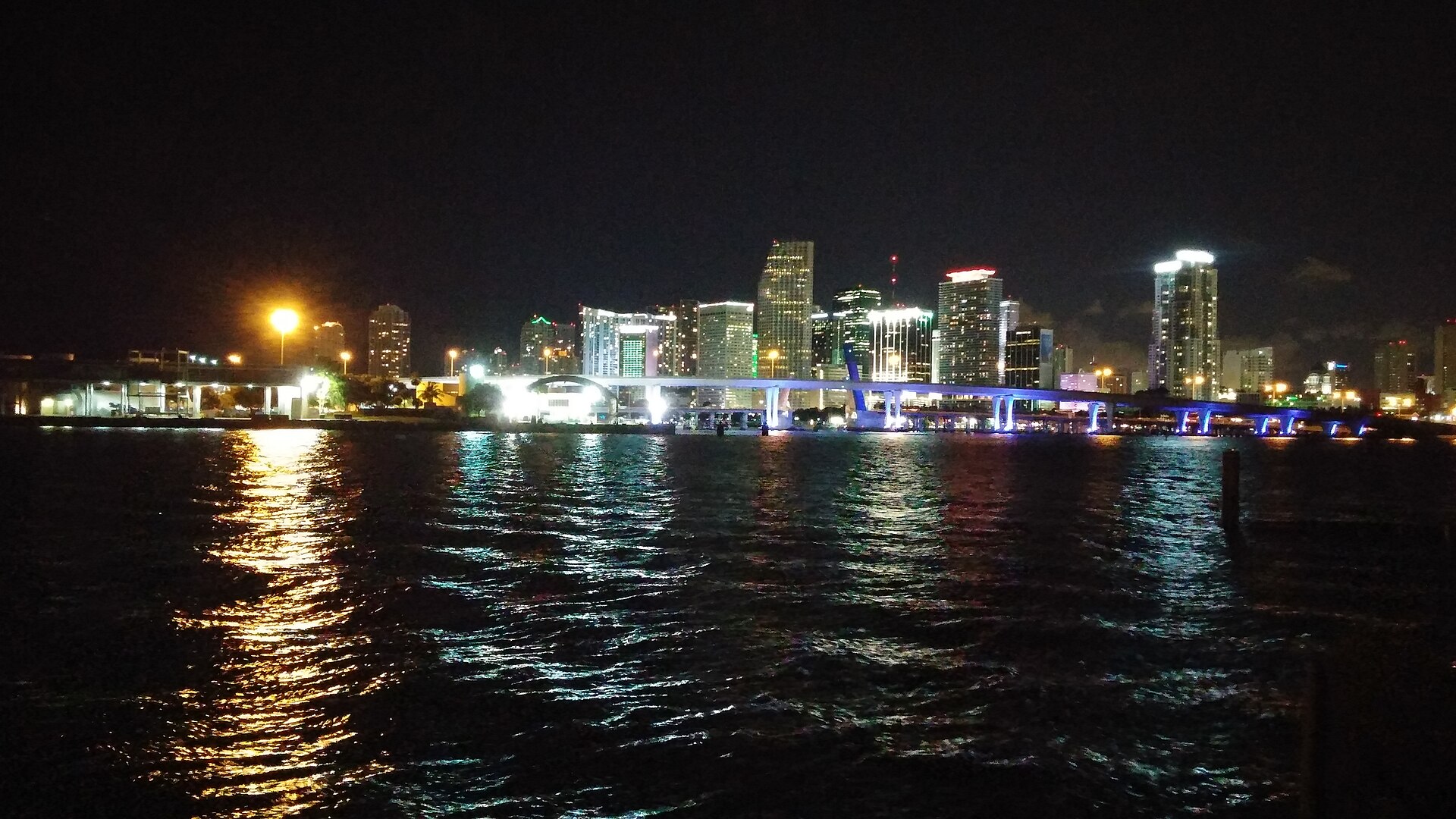 Downtown Miami’s illuminated skyline reflected across the water at night