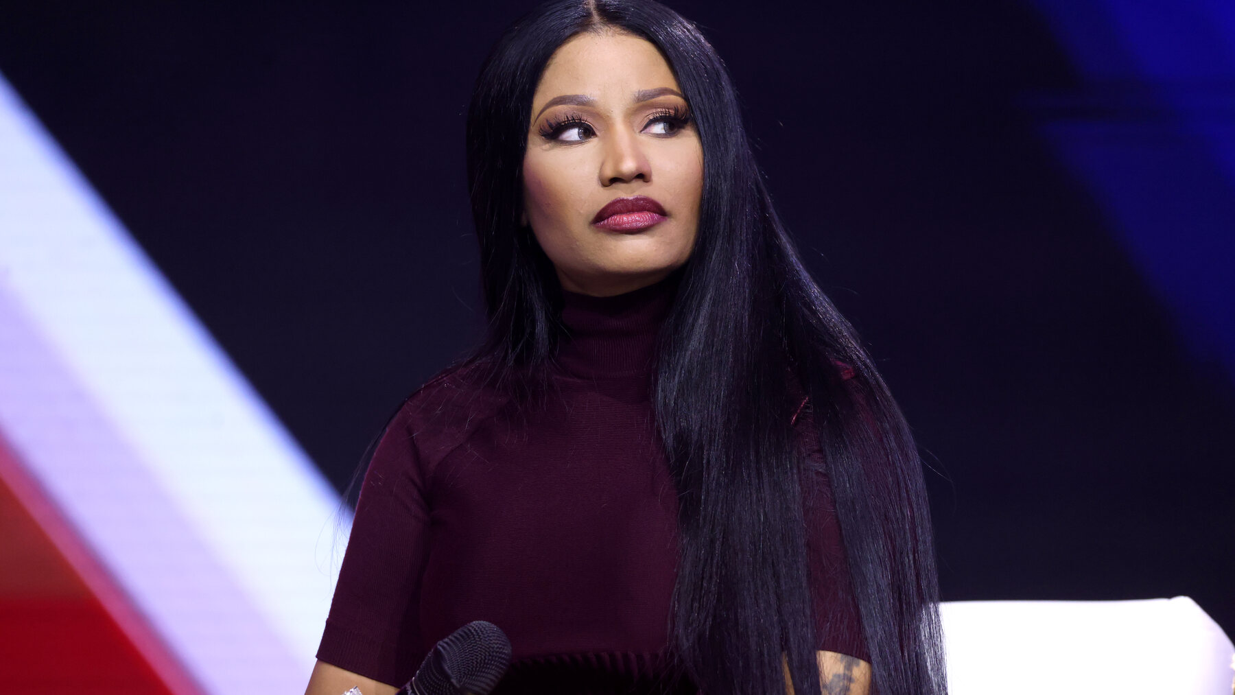 Nicki Minaj holding a microphone at AmericaFest in Phoenix in December 2025.