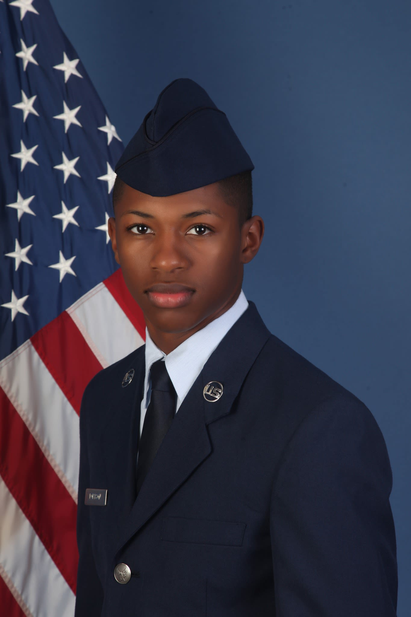 Roger Fortson in a formal United States Air Force portrait, wearing his blue service uniform beside an American flag.