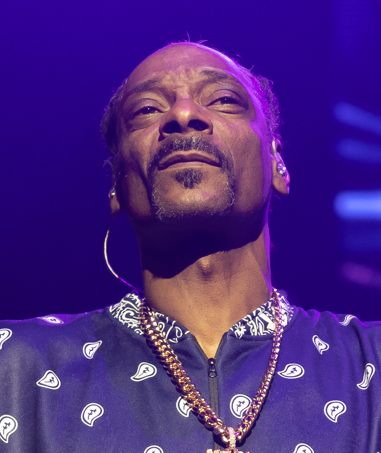 Snoop Dogg performing under purple stage lighting in Sydney in 2023